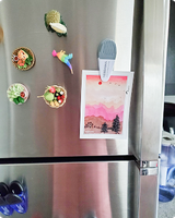 Pink sunset mountain postcard with pine trees clipped to a fridge